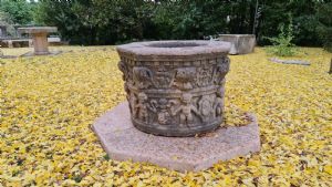 Red marble well decorated with cherubs and festoons